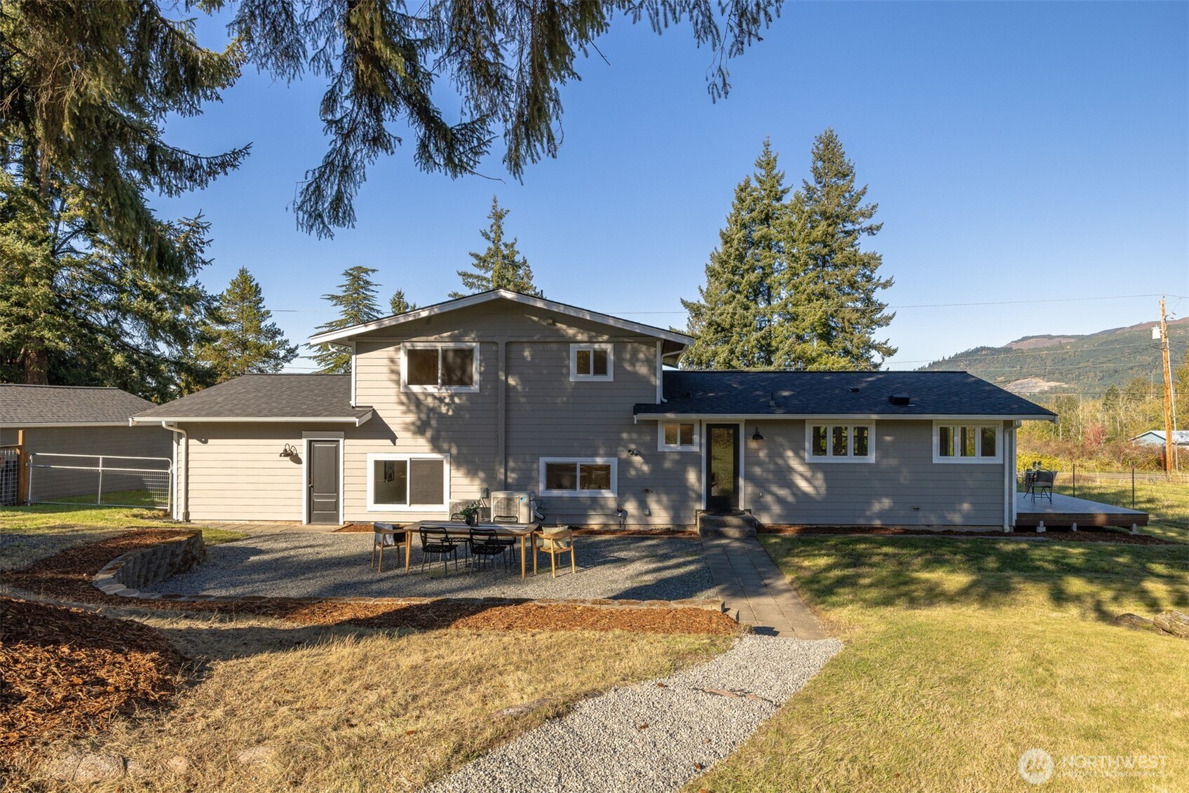 3505 East Smith Road Bellingham, WA 98226 - Photo 4 of 40 a front view of a house with a yard outdoor seating and covered with trees
