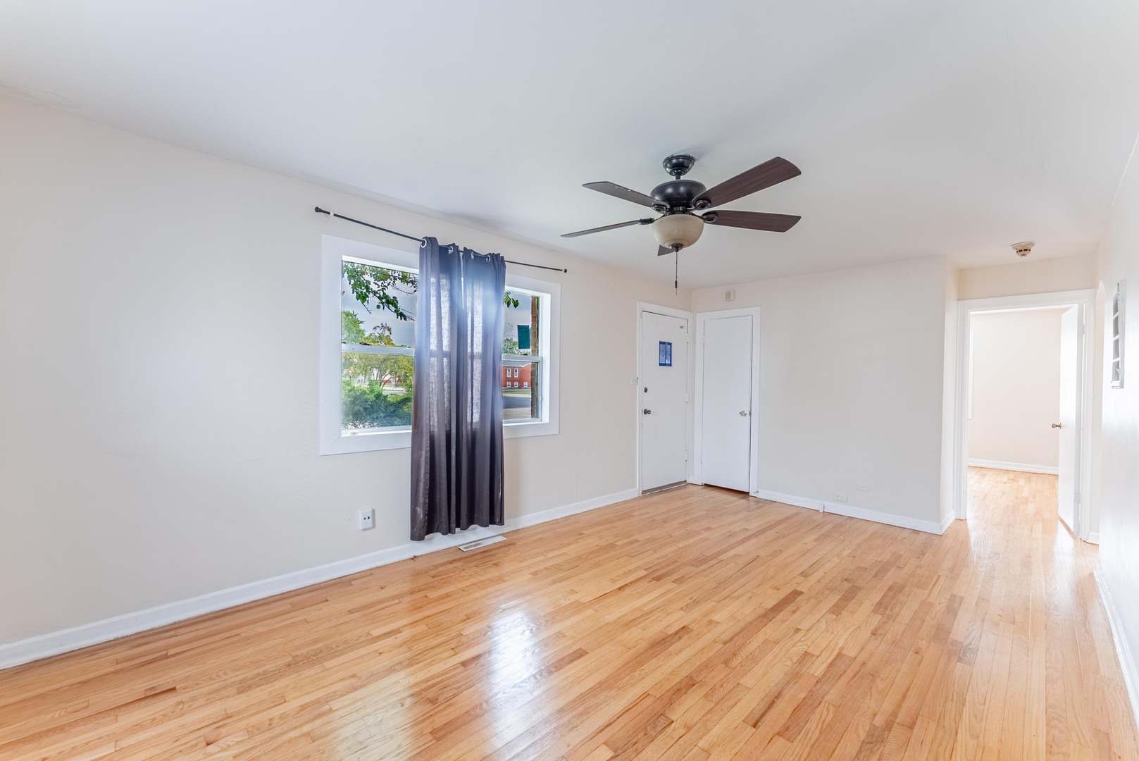 16154 Honore Avenue Markham, IL 60428 - Photo 9 of 32 a view of a room with wooden floor and a ceiling fan