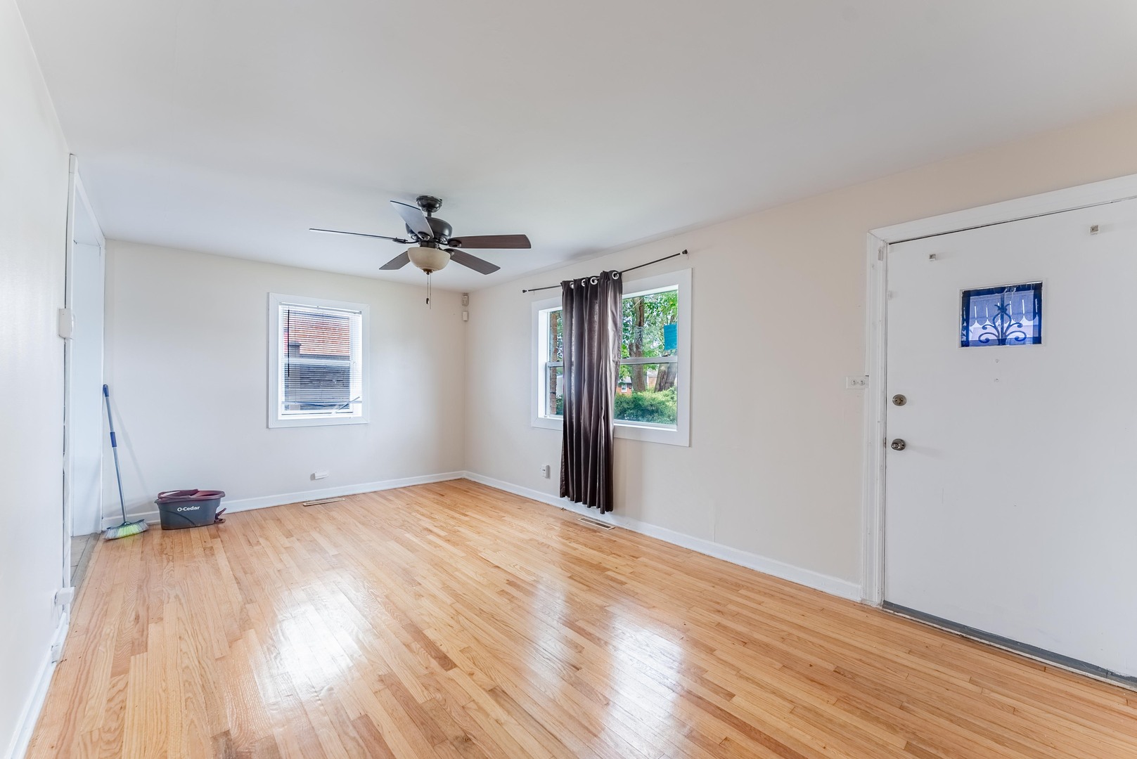 16154 Honore Avenue Markham, IL 60428 - Photo 10 of 32 a view of a livingroom with wooden floor and a ceiling fan