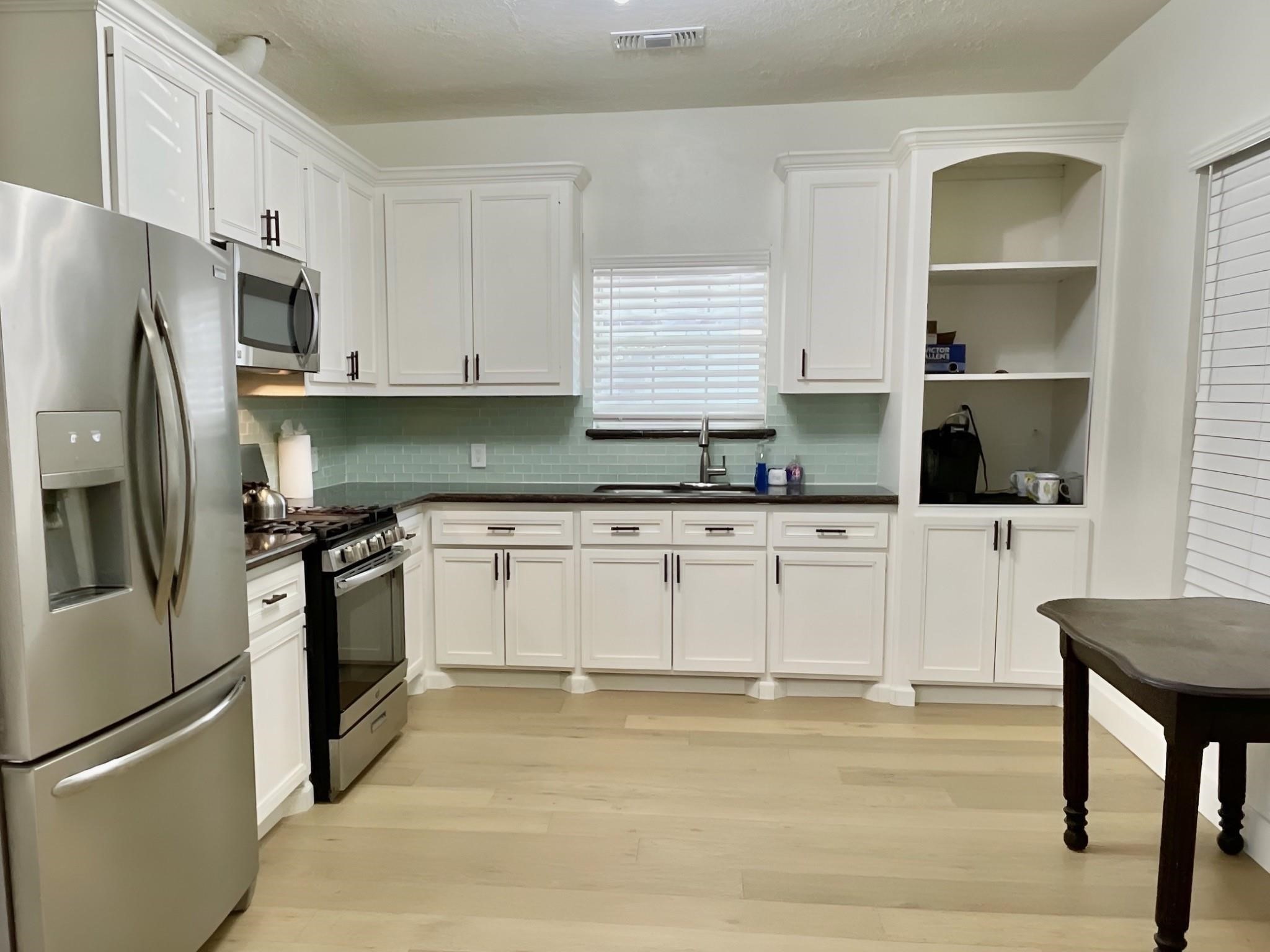 301 Tabor Street Houston, TX 77009 - Photo 5 of 14 a kitchen with granite countertop a refrigerator stove top oven and sink