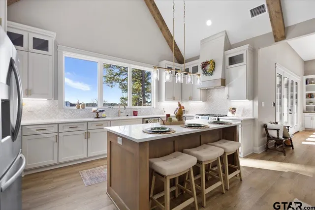 a kitchen with granite countertop a sink appliances cabinets and furniture