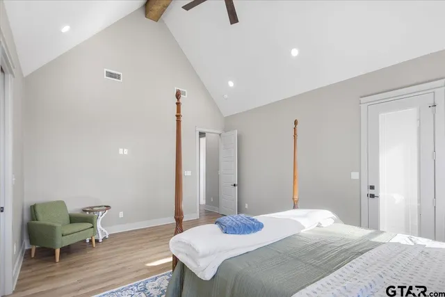 a bedroom with a bed table chair and a window