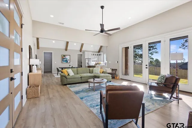a living room with furniture a ceiling fan and a rug