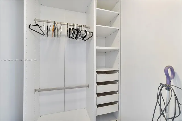 a view of walk in closet with empty racks