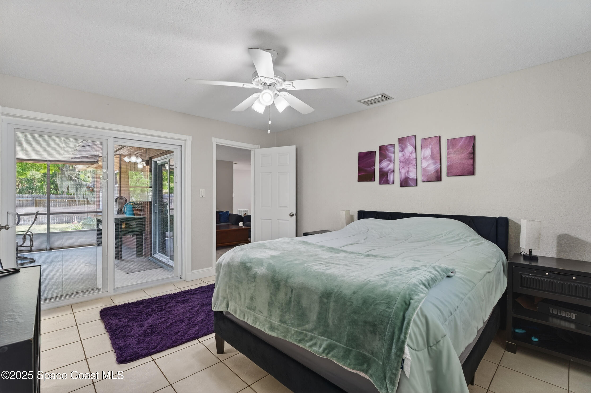 959 Macco Road Cocoa, FL 32927 - Photo 18 of 34 a bedroom with a large bed and a chandelier