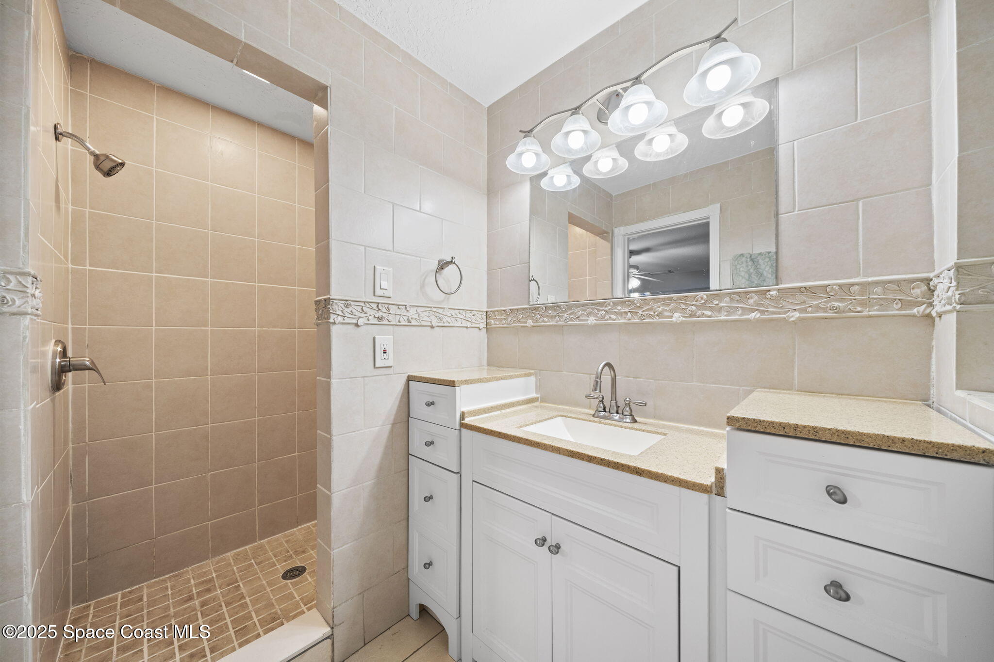 959 Macco Road Cocoa, FL 32927 - Photo 19 of 34 a bathroom with a sink a light fixture and a glass door shower