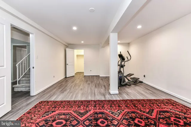 a room with gym equipment and wooden floor