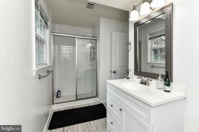 a bathroom with a sink a toilet a mirror and shower