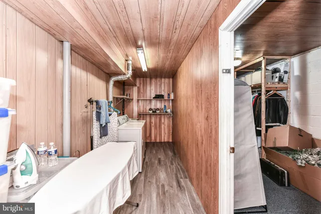 a kitchen with stainless steel appliances kitchen island granite countertop a refrigerator a sink dishwasher a stove and a dining table with wooden floor