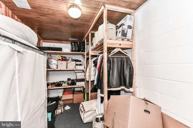 a view of walk in closet with clothes and shoes