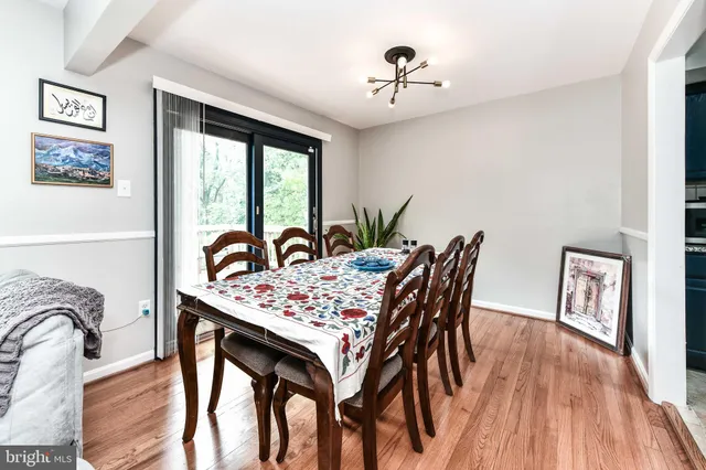 a dining room with furniture a chandelier and wooden floor