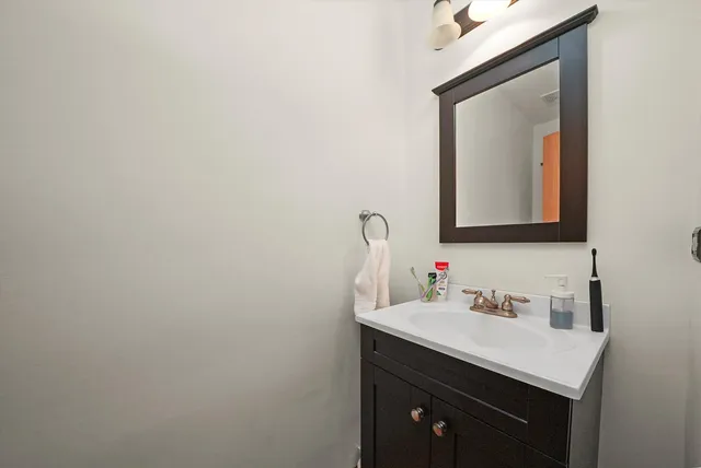 a bathroom with a sink vanity and mirror