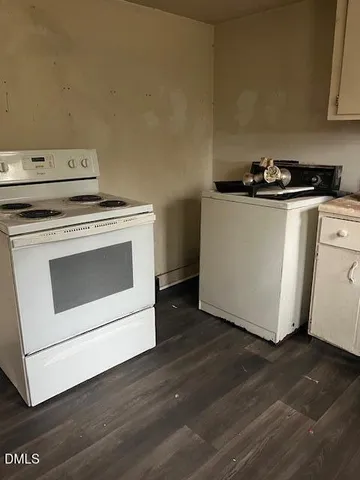 a utility room with wooden floor washer and dryer