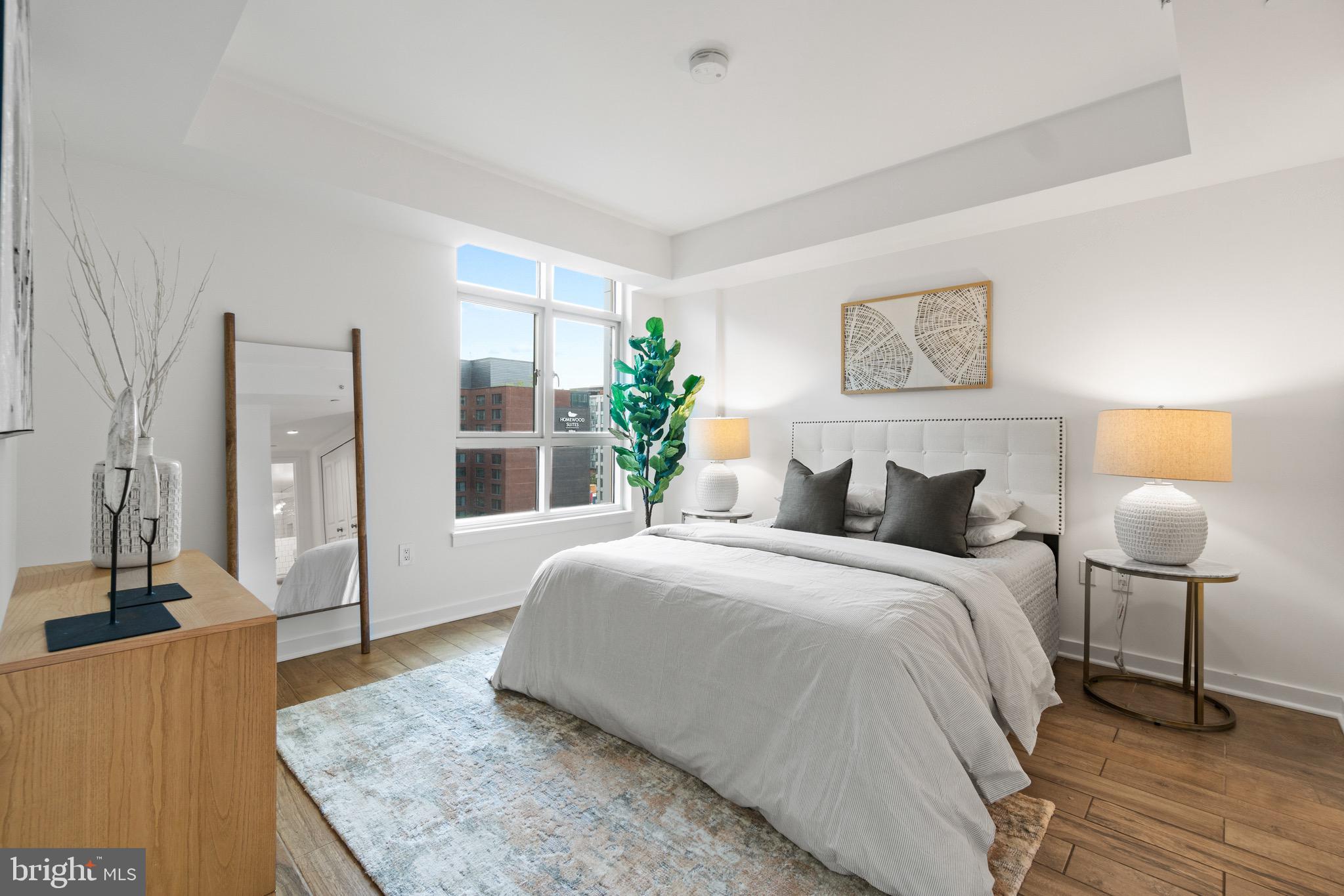 1025 First Street Southeast, Unit 1010 Washington, DC 20003 - Photo 15 of 36 a bedroom with a bed and wooden floor