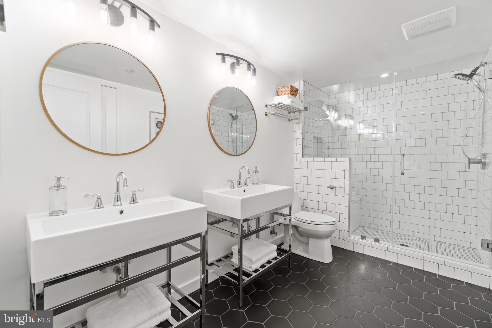 1025 First Street Southeast, Unit 1010 Washington, DC 20003 - Photo 20 of 36 a bathroom with a sink mirror and a shower