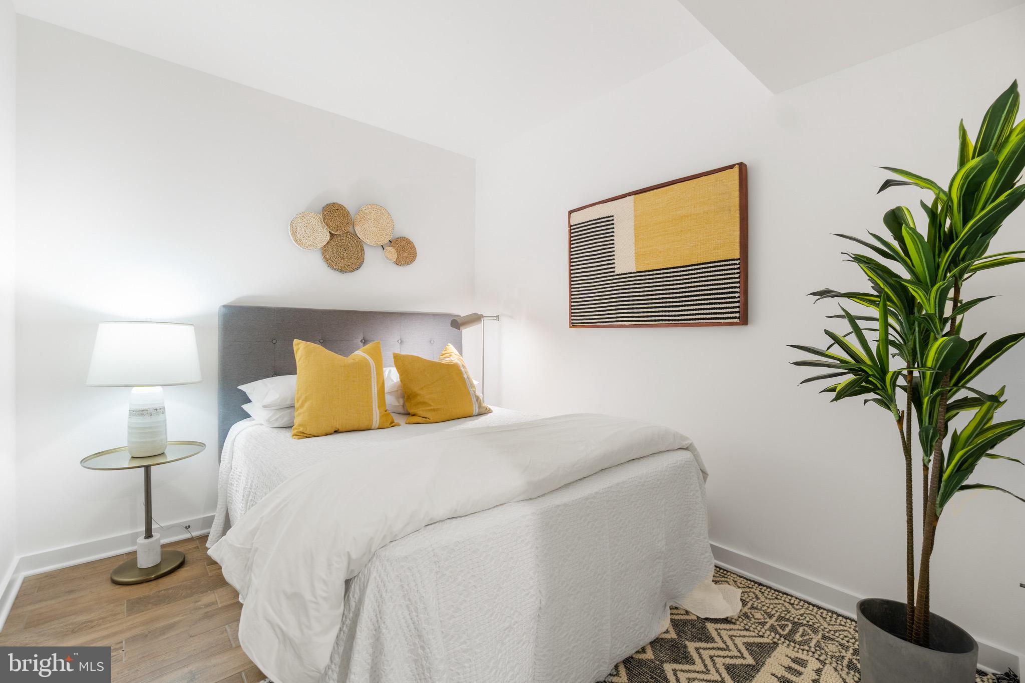 1025 First Street Southeast, Unit 1010 Washington, DC 20003 - Photo 24 of 36 a bedroom with a bed and a potted plant