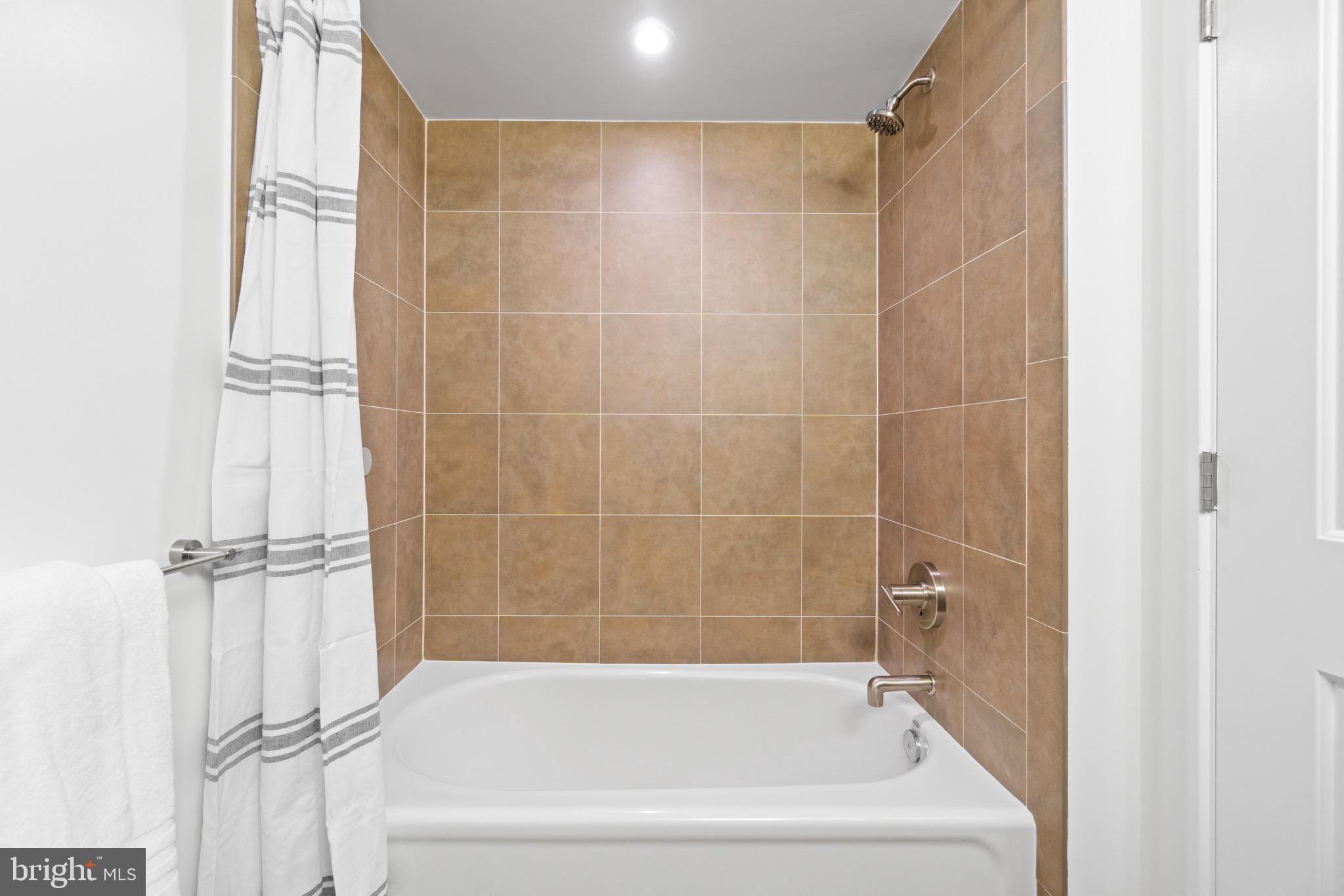 1025 First Street Southeast, Unit 1010 Washington, DC 20003 - Photo 27 of 36 a white bath tub sitting next to a white sink and vanity