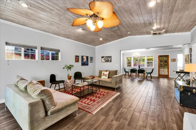 a large white kitchen with granite countertop a stove a sink a window and a dining table