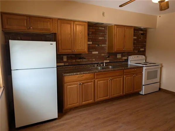 a kitchen with stainless steel appliances granite countertop a refrigerator a sink and cabinets