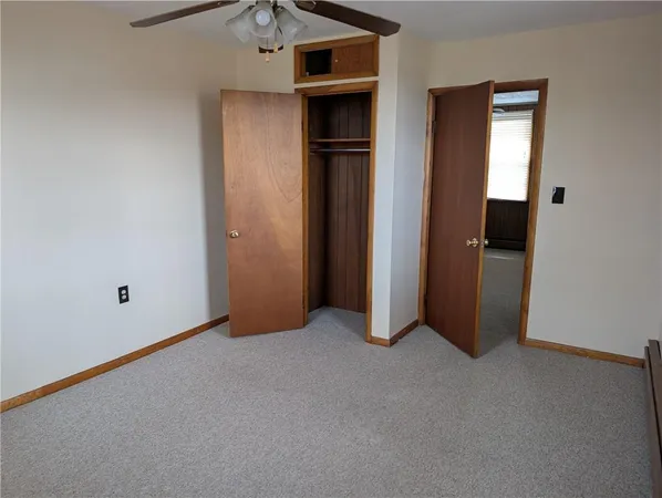 an empty room with closet and wooden door