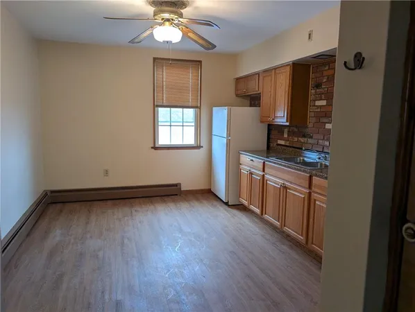 a kitchen with stainless steel appliances a stove top oven a sink dishwasher and a refrigerator with wooden floor