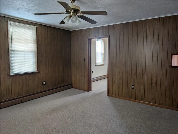 an empty room with windows and cabinet