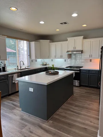 a kitchen with stainless steel appliances granite countertop a sink counter space and cabinets