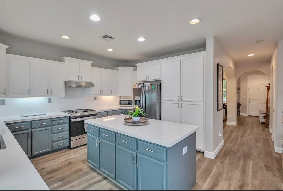 10647 Spring Creek Place Stockton, CA 95209 - Photo 11 of 24 a kitchen with a sink a refrigerator and white cabinets