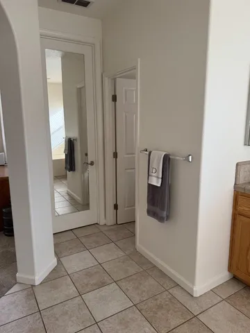 a view of a hallway with wooden floor and a bathroom