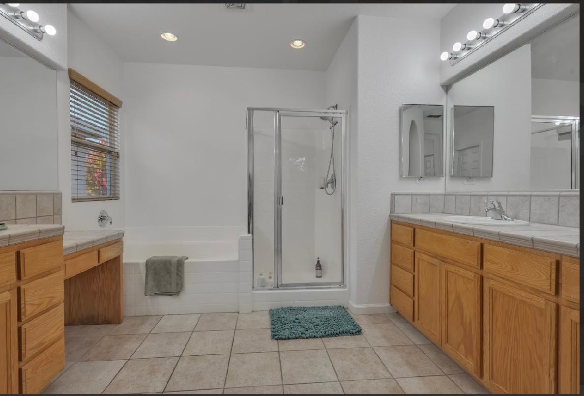 10647 Spring Creek Place Stockton, CA 95209 - Photo 17 of 24 a spacious bathroom with a granite countertop sink a mirror and a bathtub