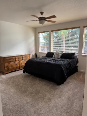a spacious bedroom with a bed and a large window