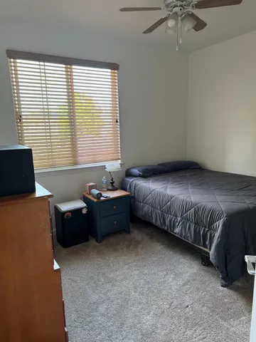 a bedroom with a bed and a dresser next to a window