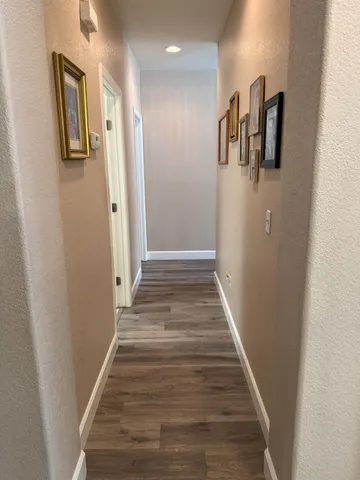 a view of a hallway with wooden floor and staircase