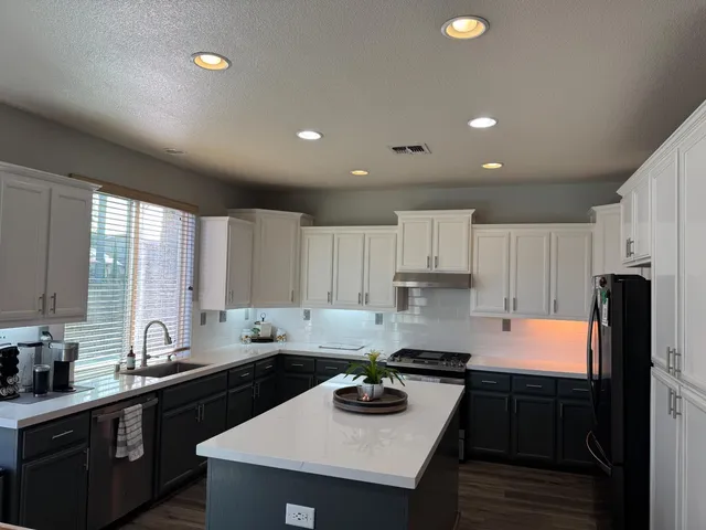 a kitchen with granite countertop a sink stove and refrigerator