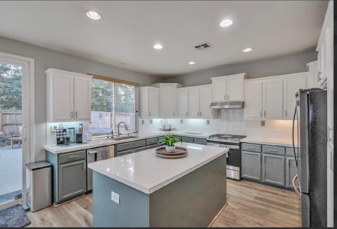 10647 Spring Creek Place Stockton, CA 95209 - Photo 10 of 24 a kitchen with stainless steel appliances a sink stove and refrigerator