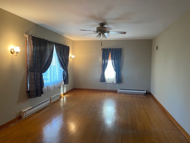 312 Walnut Street Leonore, IL 61332 - Photo 6 of 13 an empty room with wooden floor and windows