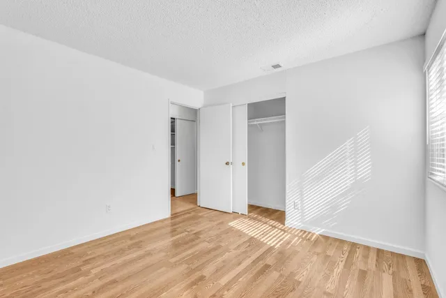 a view of an empty room with wooden floor