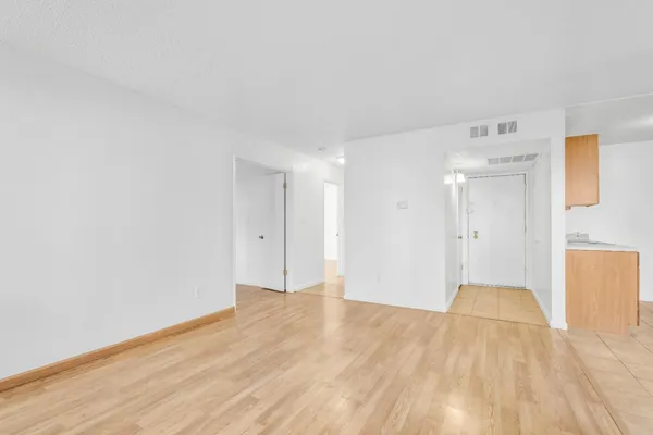 a view of empty room with wooden floor