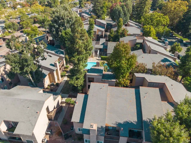 an aerial view of residential houses with outdoor space and ocean view
