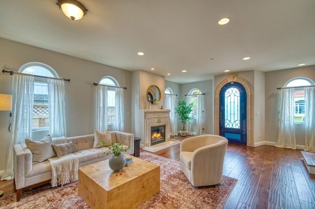 a kitchen with a center island wooden floor and stainless steel appliances