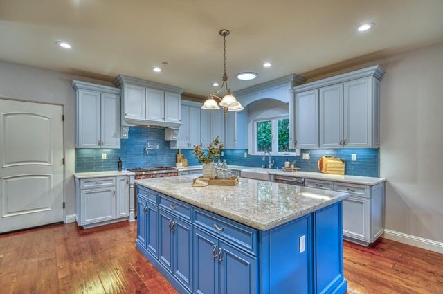a kitchen with stainless steel appliances a stove a sink and cabinets
