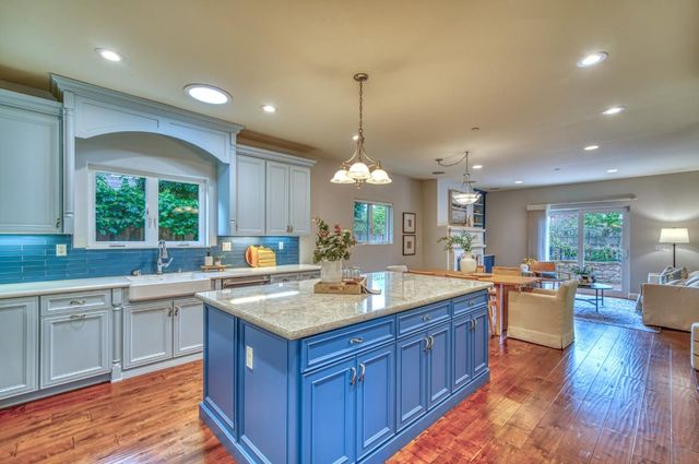 a kitchen with kitchen island granite countertop stainless steel appliances and wooden cabinets