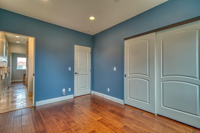 a bedroom with bed and wooden floor