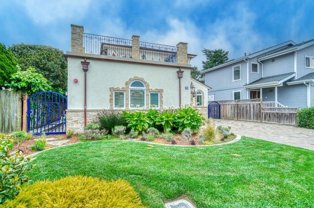 a front view of a house with a garden and plants