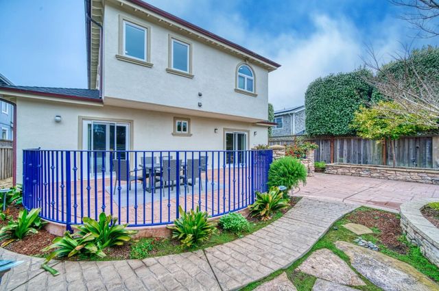 a front view of a house with a yard and a garden