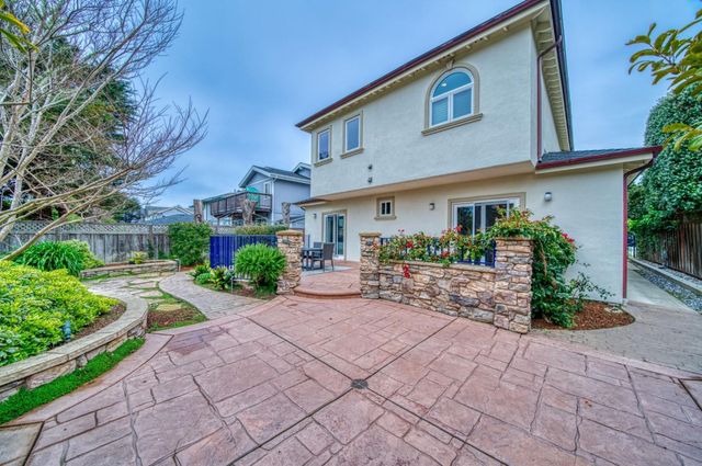 a view of a backyard with brick wall and plants
