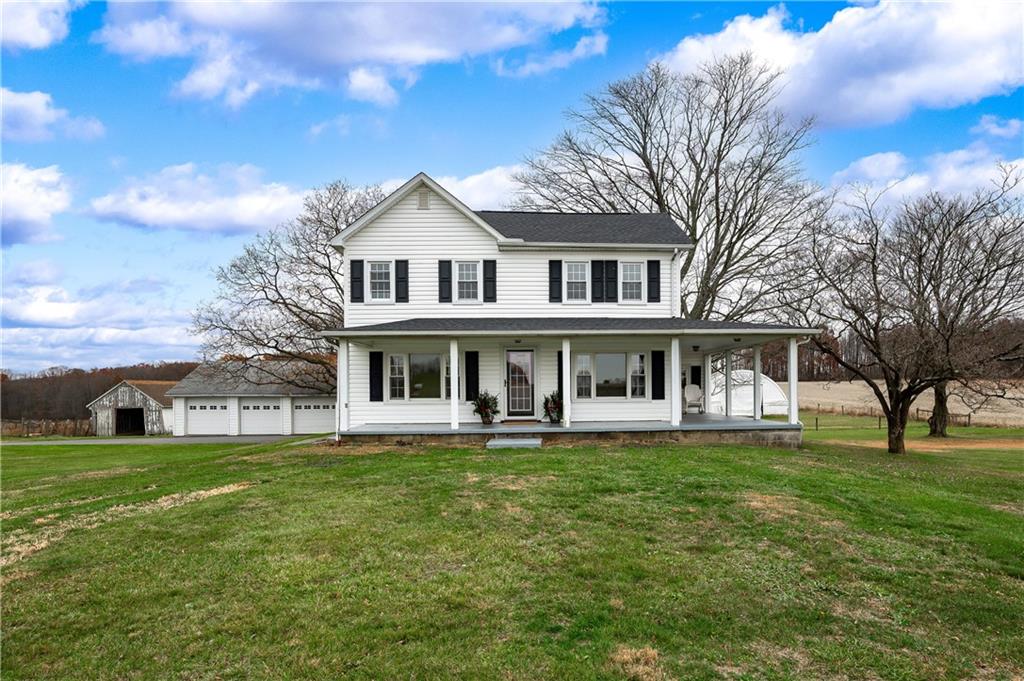 a view of a house with a big yard and large trees