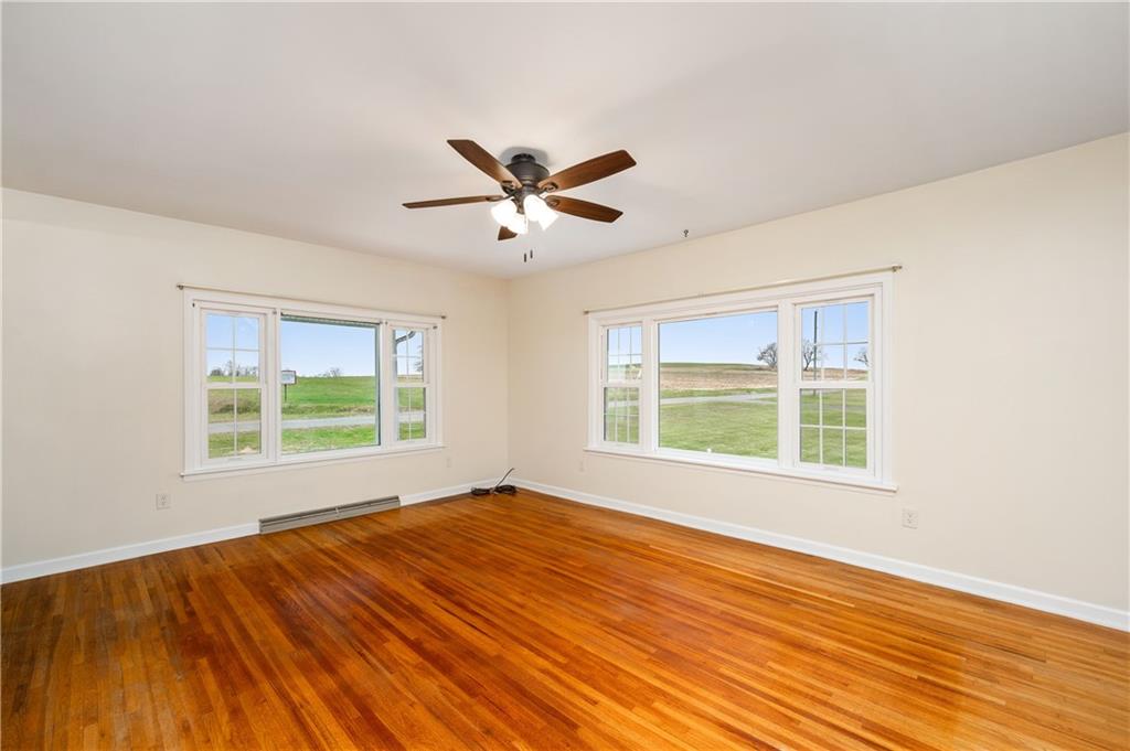 1080 Breakneck Bridge Road Portersville, PA 16051 - Photo 11 of 45 a view of an empty room with wooden floor and a window