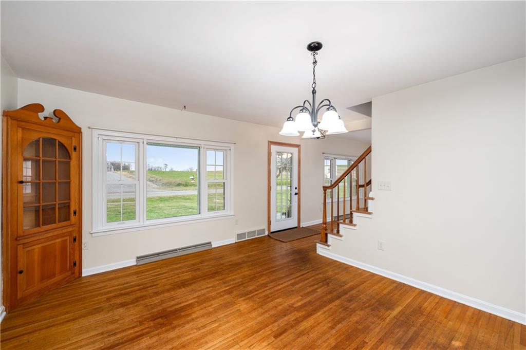 1080 Breakneck Bridge Road Portersville, PA 16051 - Photo 13 of 45 a view of a room with wooden floor staircase and a chandelier