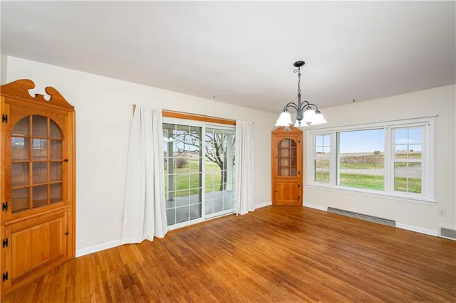a view of a room with wooden floor chandeliers and kitchen